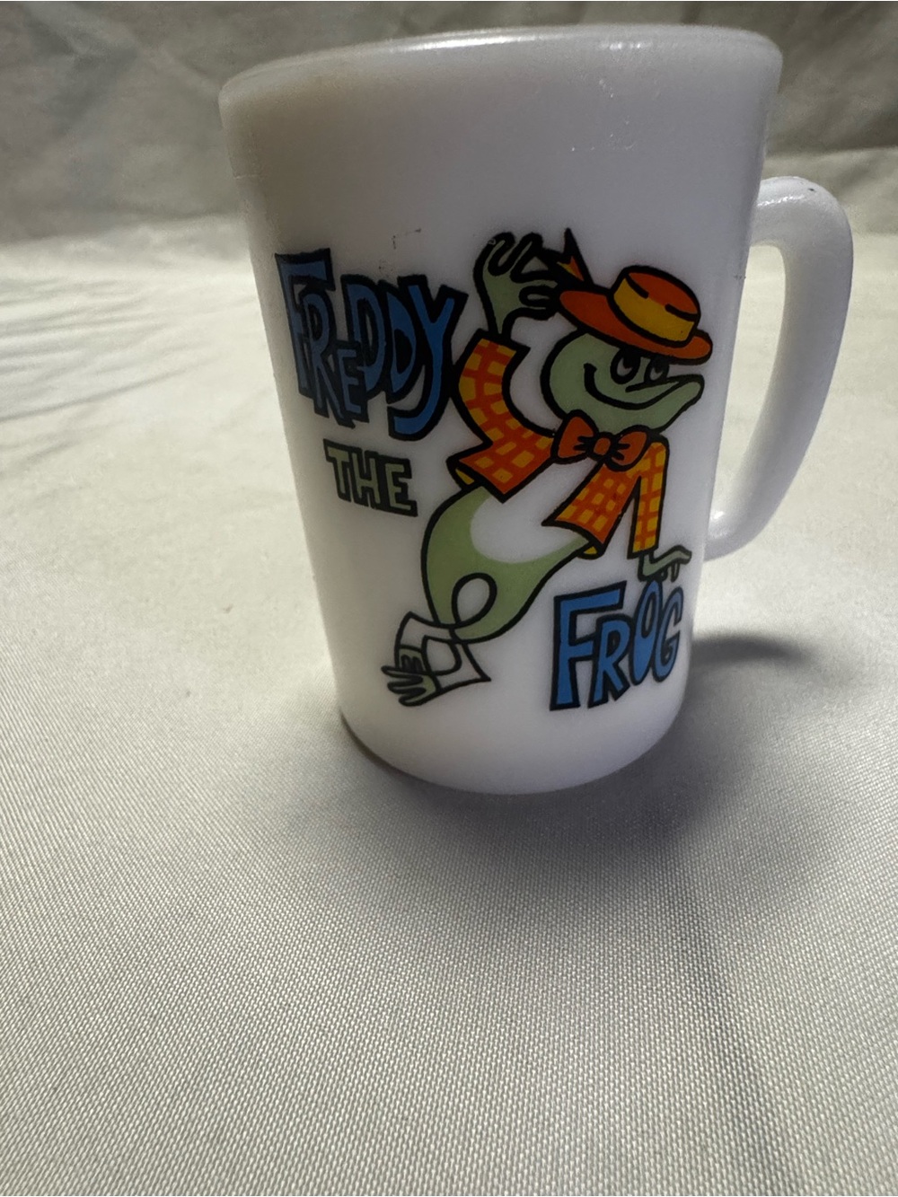 Avon White Mug with Green Freddy the Frog, Orange Hat and Blue Lettering